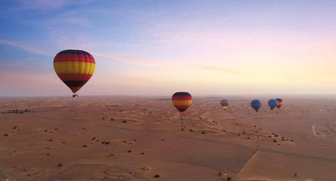 Hot air balloon sunrise over Dubai desert dunes